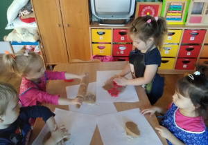 Dzieci przygotowują pierniczki do pieczenia.